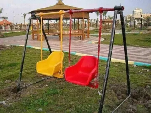 مراجيح أطفال بمقاعد فيبر جلاس في حديقة